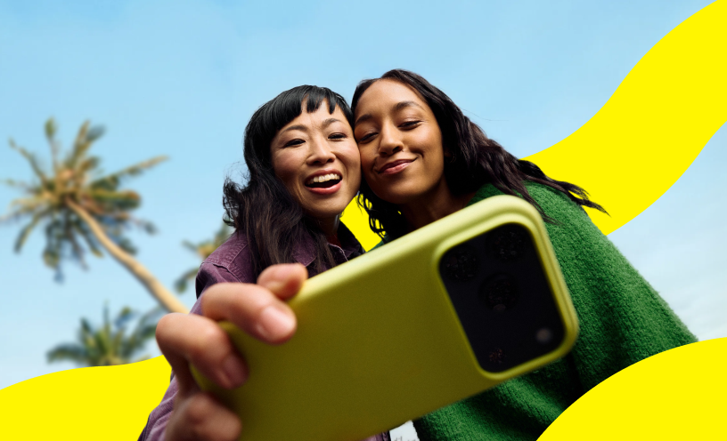 Saily campaign image of two travelers taking a smartphone selfie