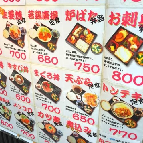 Japanese restaurant menu board written in Japanese with dish photos and prices