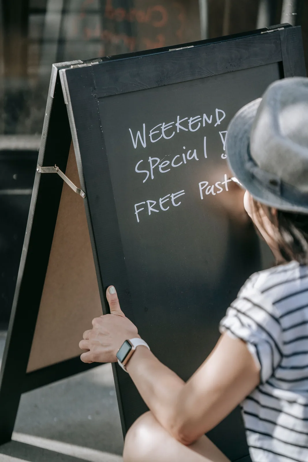 Man writing a restaurant chalkboard sign