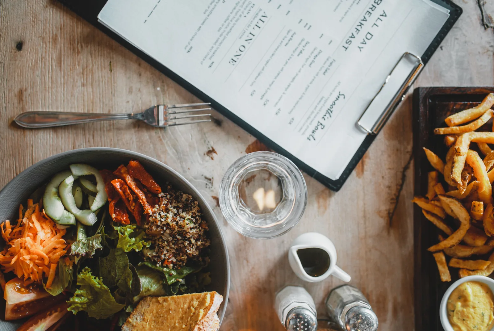 Restaurant table with a menu and shared dishes
