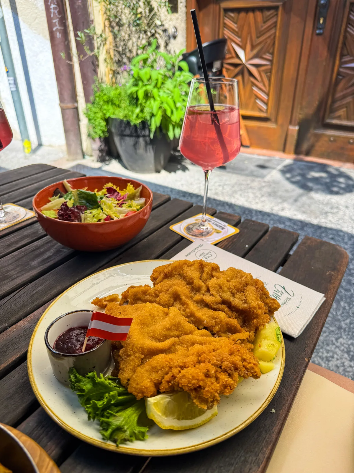 Schnitzel and salad plate at an outdoor German restaurant table