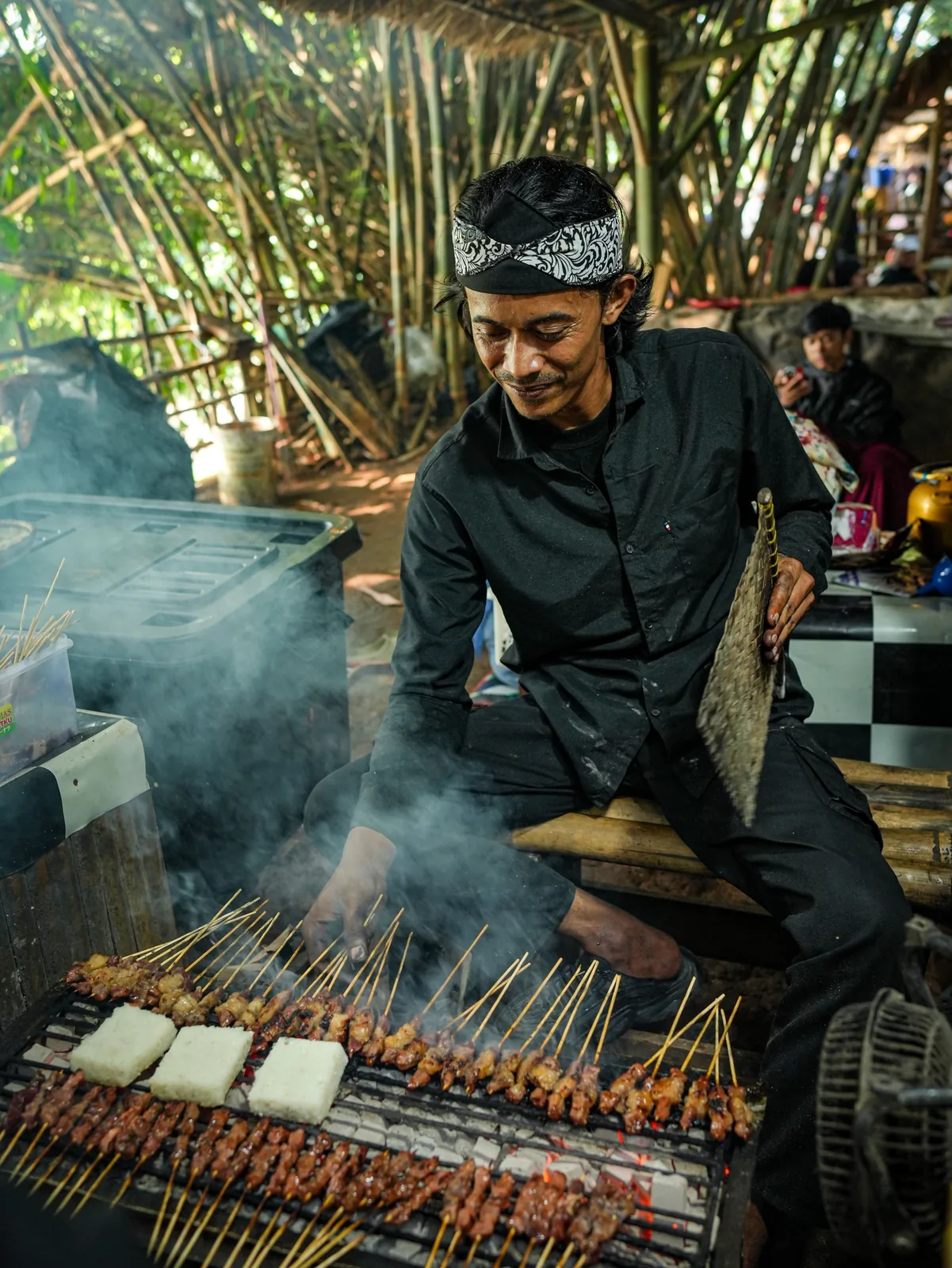Chef grilling satay skewers at a night market in Indonesia