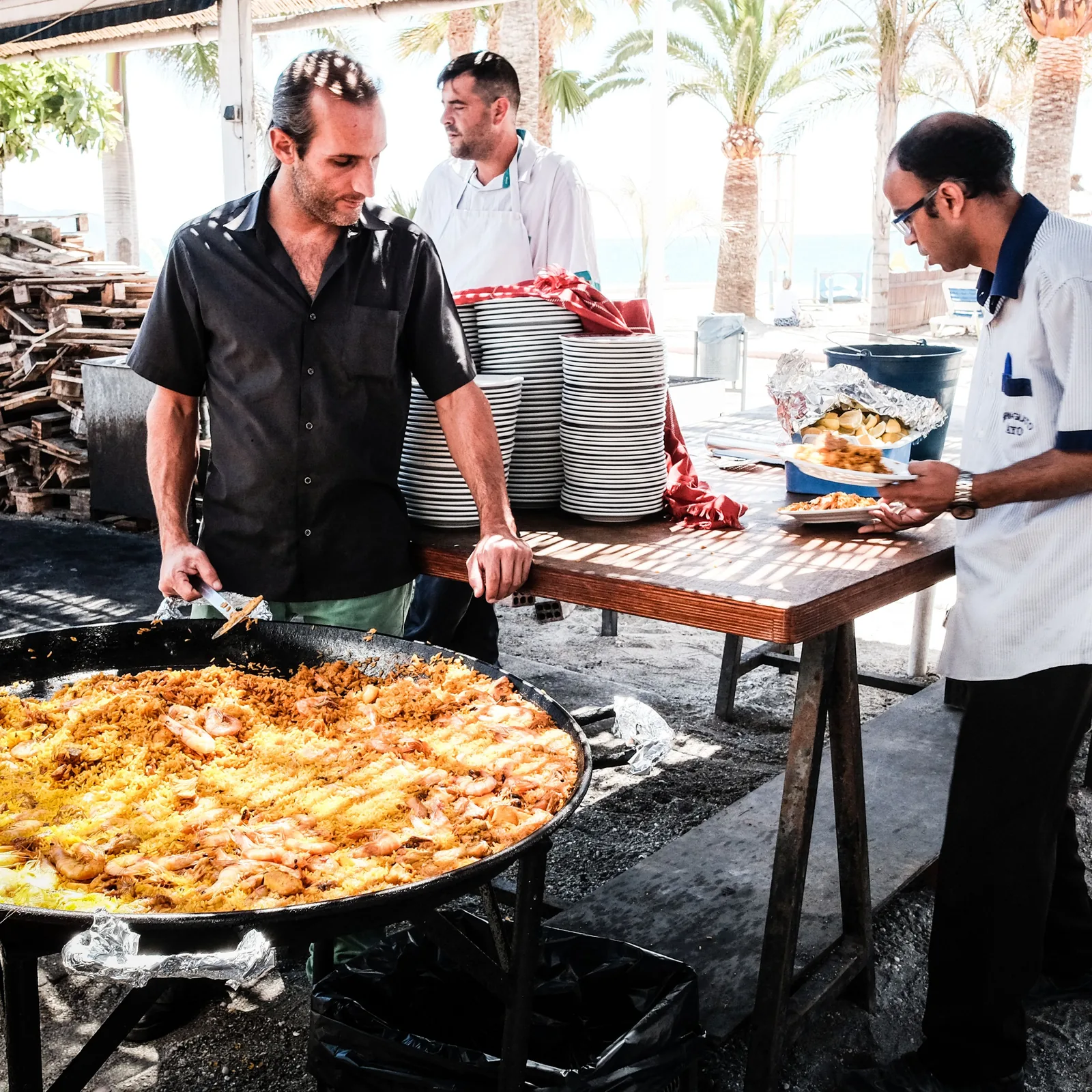 Chefs preparing pizza at an outdoor market stall in Italy