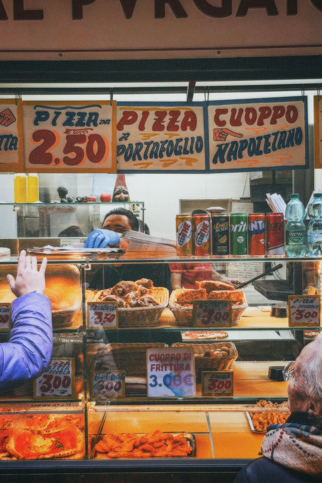 Pizza shop storefront with menu signage in Naples, Italy