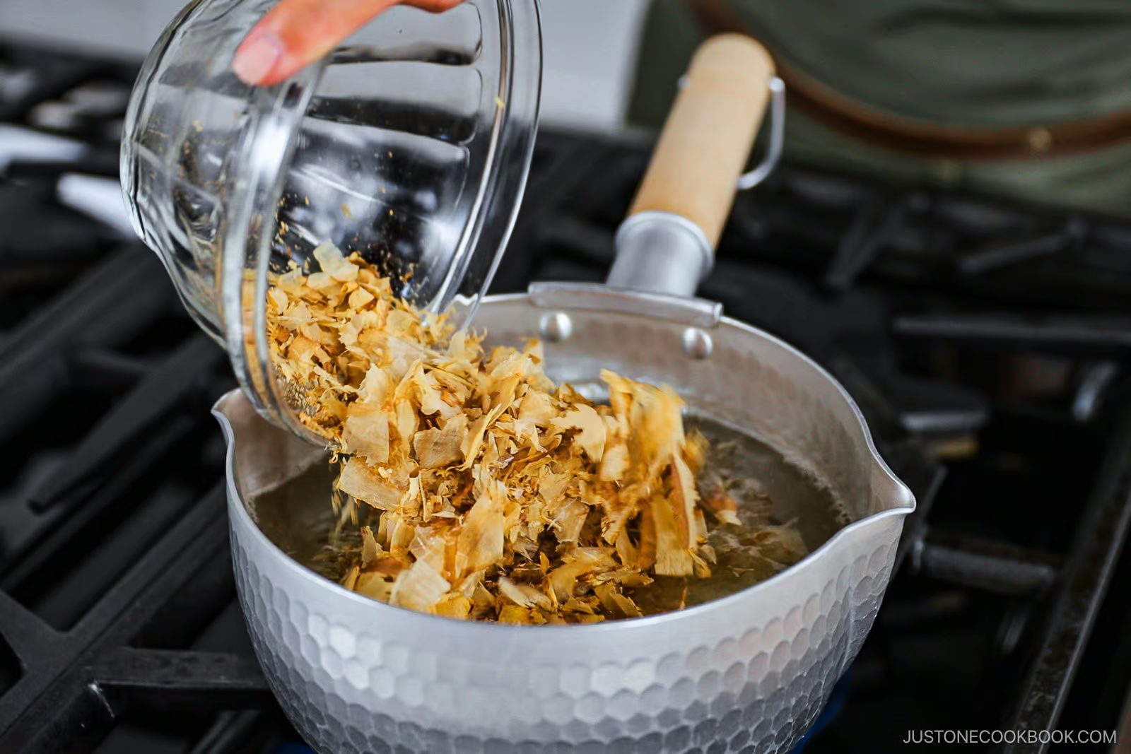 Traditional Japanese dashi stock being prepared with bonito flakes