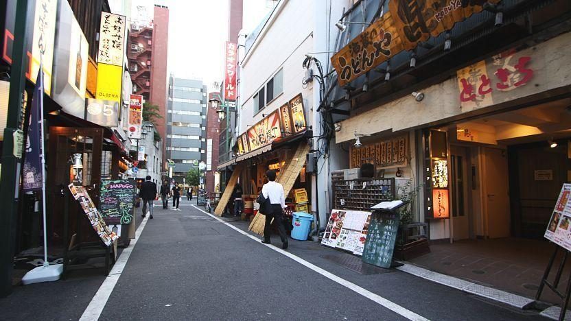 Narrow Tokyo izakaya alley lined with restaurant signs at night