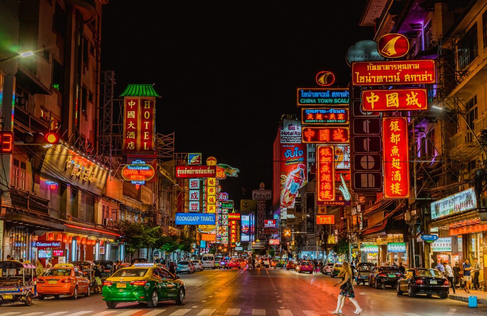 Neon signage and food stalls on Yaowarat Road in Bangkok's Chinatown at night