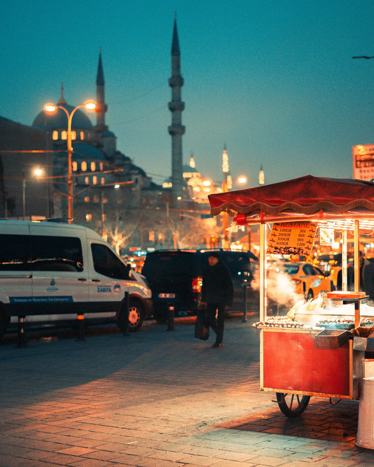 Street food cart in Istanbul at dusk with a mosque in the background