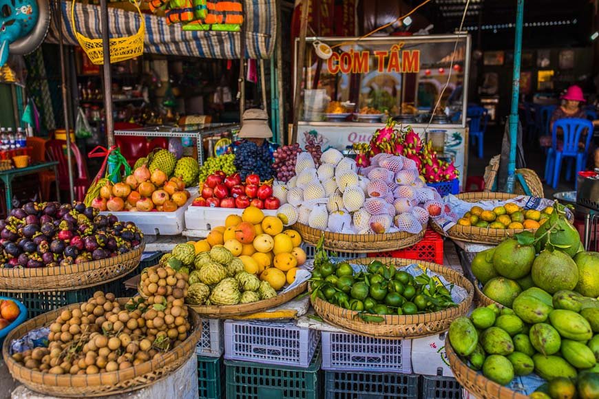 Vietnamese fresh fruit stall selling mango and pineapple, a simpler street-food option to check for allergies