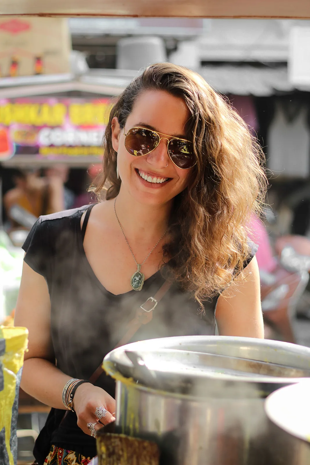 Street food vendor cooking in a large pot at her stall