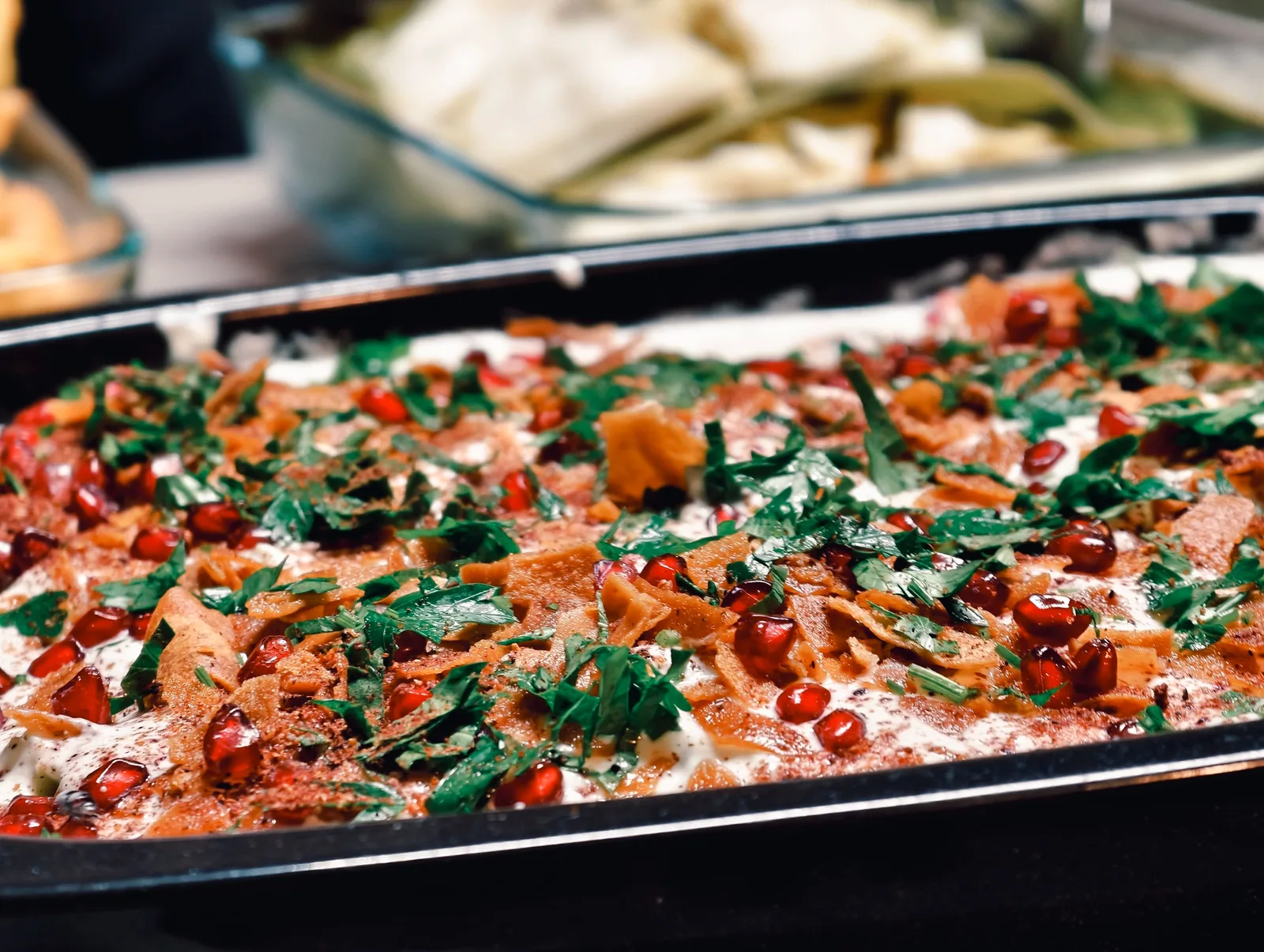 Herb and tomato flatbread served overhead on a wooden board