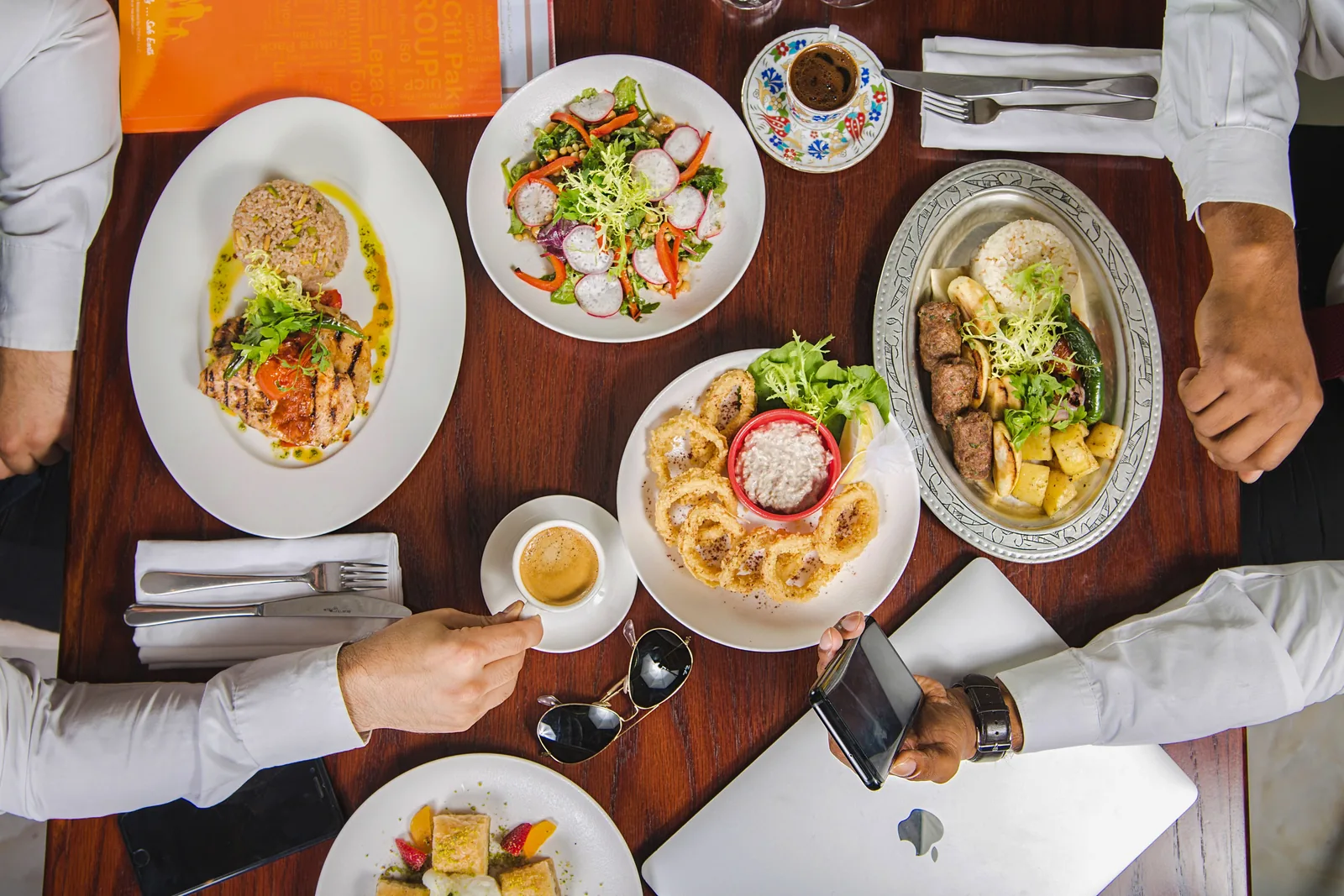 Overhead view of a shared table with multiple restaurant dishes