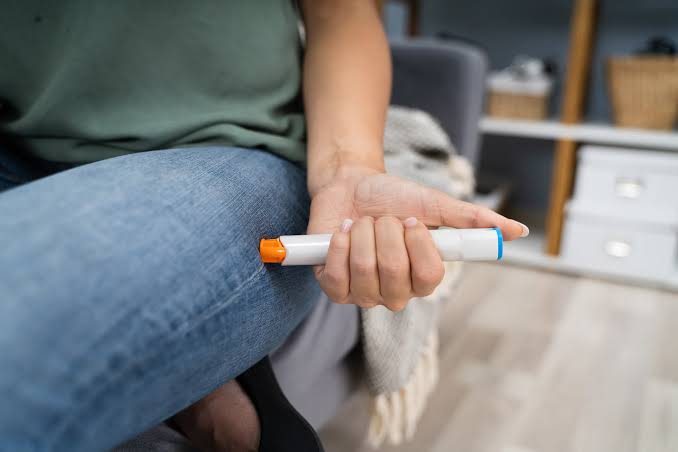 Hand holding an adrenaline auto-injector